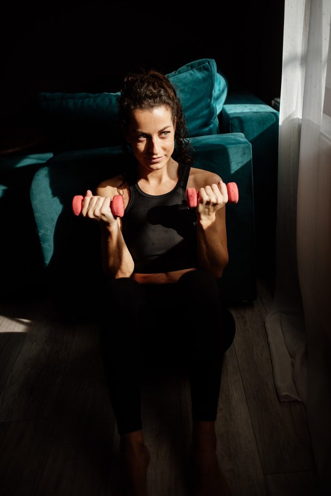 A Woman Engages In Strength Training Exercises Using Pink Dumbbells Wh — Sports & Fitness | RESIMLAND